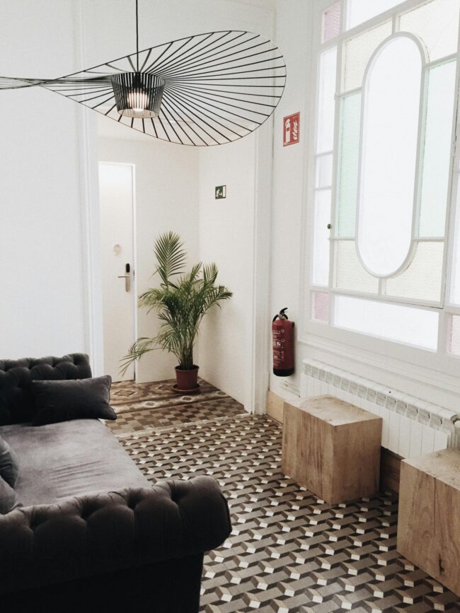 Elegant living room with geometric flooring, plush sofa, and tasteful decor.