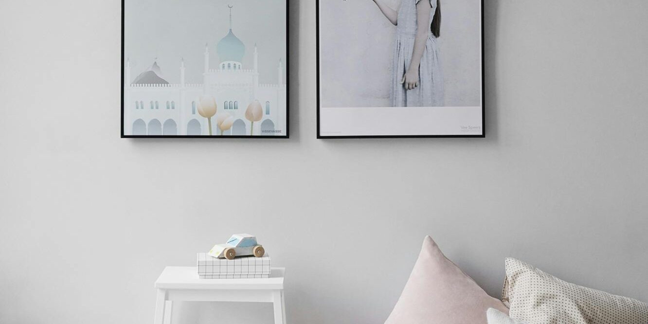 Minimalist Scandinavian bedroom with wall art and cozy decor elements.