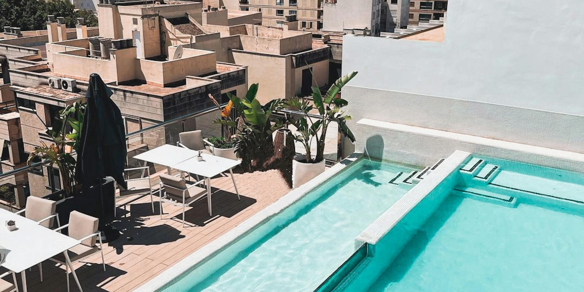 A beautiful rooftop terrace with a swimming pool overlooking a city's skyline, perfect for relaxation.