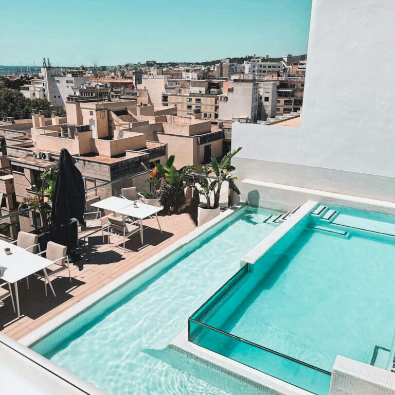 A beautiful rooftop terrace with a swimming pool overlooking a city's skyline, perfect for relaxation.