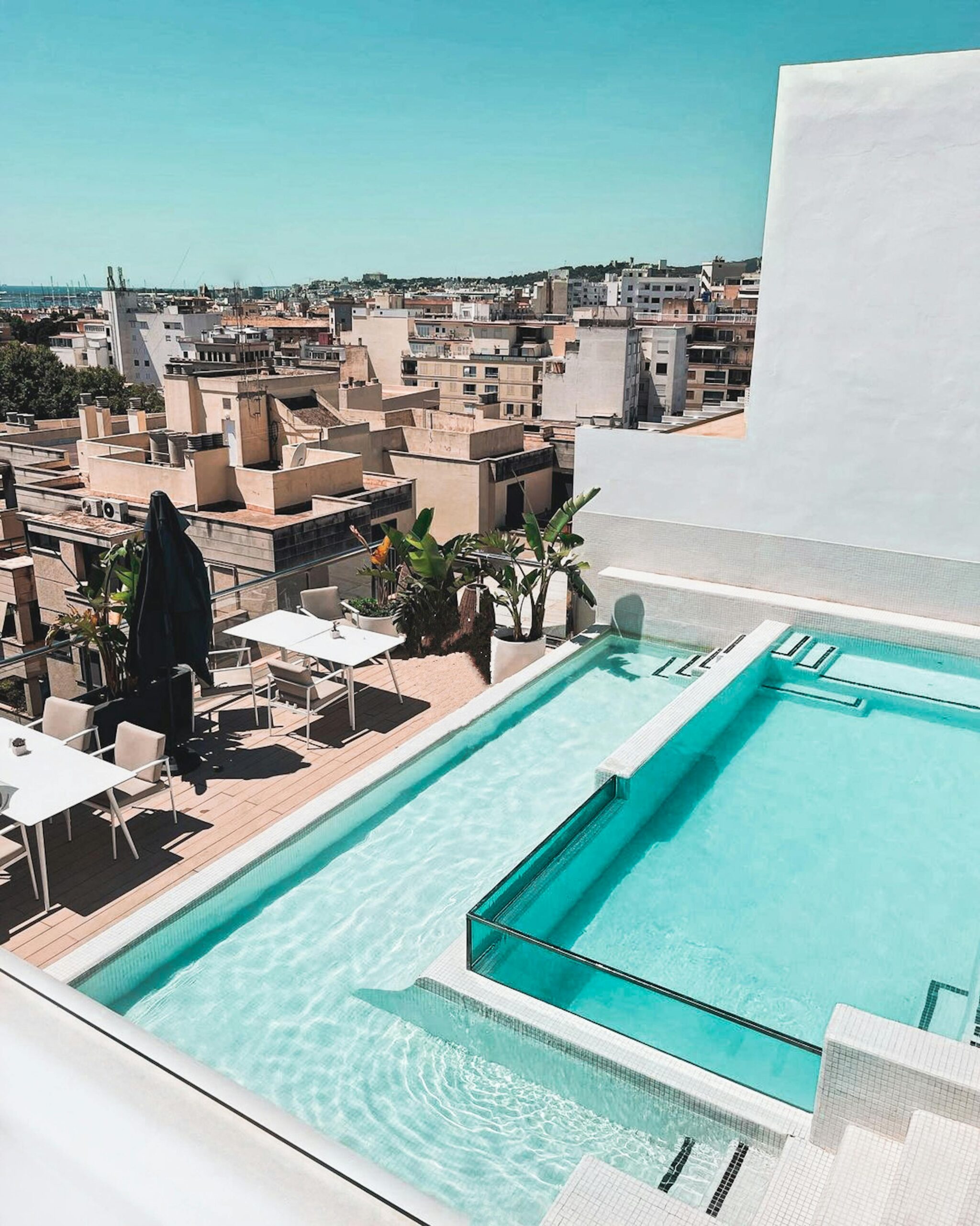 A beautiful rooftop terrace with a swimming pool overlooking a city's skyline, perfect for relaxation.